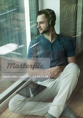 Young Man Listening to Music through Headphones at Home, Mannheim, Baeden-Wurttemberg, Germany