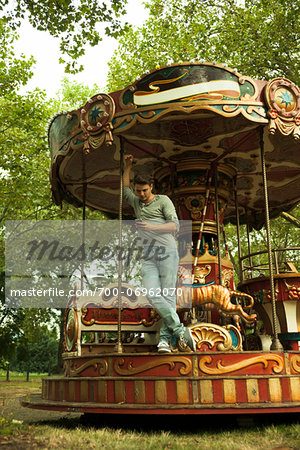 Young Man using Cell Phone while Standing on Edge of Carousel, Mannheim, Baden-Wurttemberg, Germany