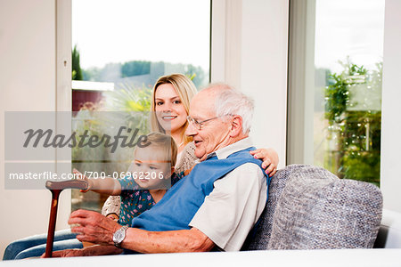 Young Woman with Baby Girl and Senior Man on Sofa, Mannheim, Baden-Wurttemberg, Germany