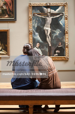 France, Paris, Young couple watching paintings in Louvre Museum