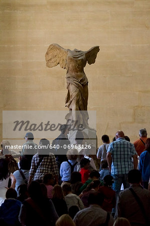 France, Paris, The Louvre, Tourists looking at Winged Victory of Samothrace