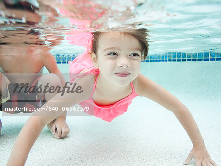USA, Utah, Orem, Boy (4-5) and girl (4-5) swimming in pool
