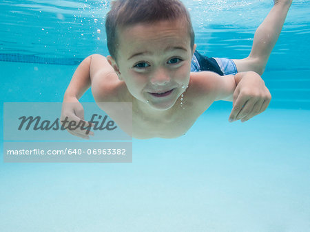 USA, Utah, Orem, Boy (6-7) swimming in pool