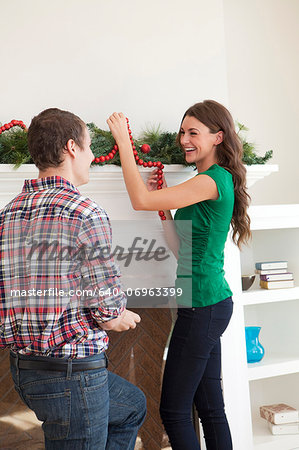 Smiling couple decorating room for Christmas