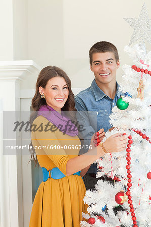 Young couple decorating Christmas tree