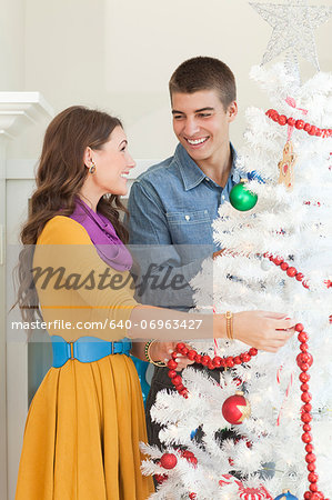 Young couple decorating Christmas tree