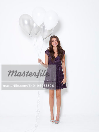 Portrait of young woman holding balloons at party