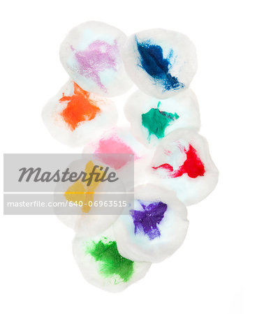 Cotton pads stained with colorful paint on white background