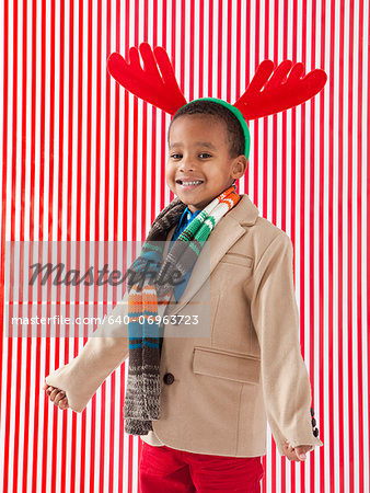 Boy (4-5) wearing reindeer antlers, studio shot
