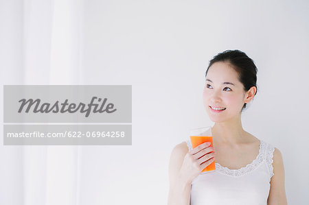 Young woman with vegetable juice smiling away