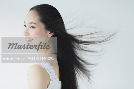 Young woman with fluttering hair smiling