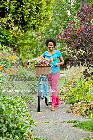 Woman riding retro bicycle with flower basket