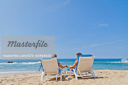 Rear view of couple in beach chairs