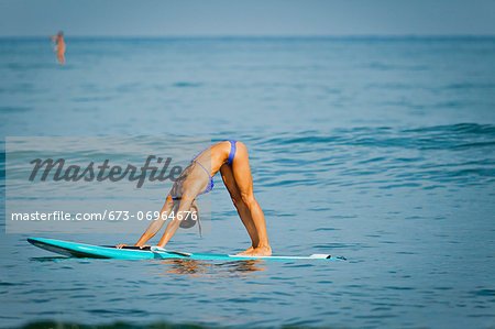 Woman in yoga pose on paddle board