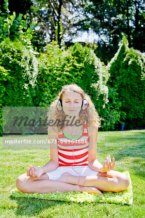 Teen girl meditating outdoors