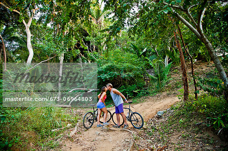 Couple riding bicycles on jungle path