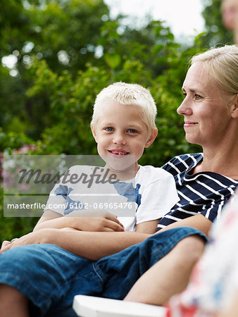 Mother and boy sitting in outdoor chair
