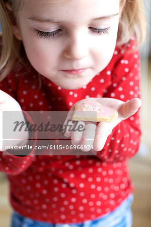 Little girl holding heart shaped cookie, Muich, Bavaria, Germany