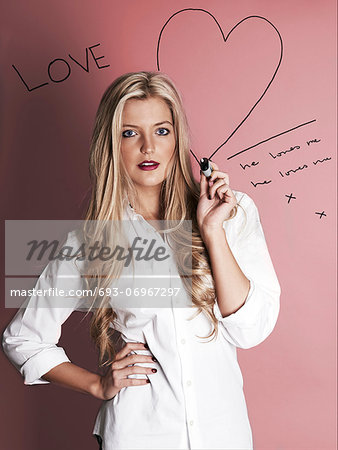 Blonde woman with marker pen drawing hearts