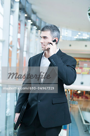 Businessman walking and talking on mobile phone
