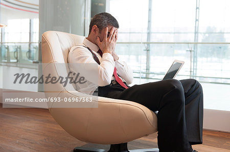 Stressed out businessman covers face with hands