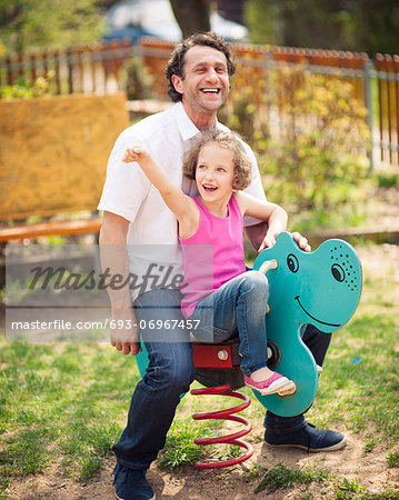 Father and daughter on playground spring rider