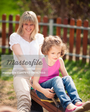 Mother and daughter ride seesaw together