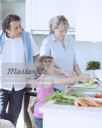 Family making a healthy salad in the kitchen