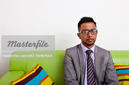 Businessman sitting on sofa looking at camera