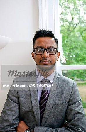Portrait of Indian Businessman wearing glasses with hands folded