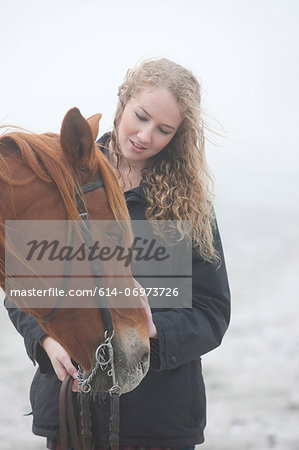 Woman with horse on beach