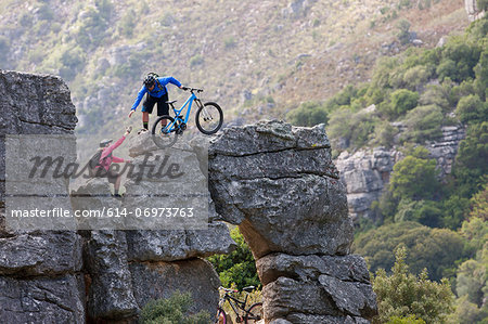 Mountain biking couple climbing rock formation