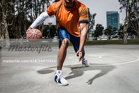 Young man playing basketball on court, close up