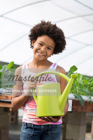 Girl holding green watering can