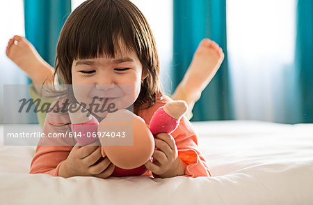 Girl playing with dolly in bedroom Girl playing with dolly in bedroom