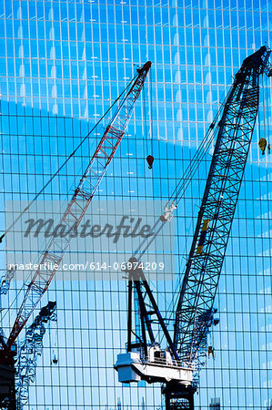 Construction cranes in front of office building