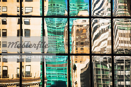 Modern glass facade reflecting varied office buildings