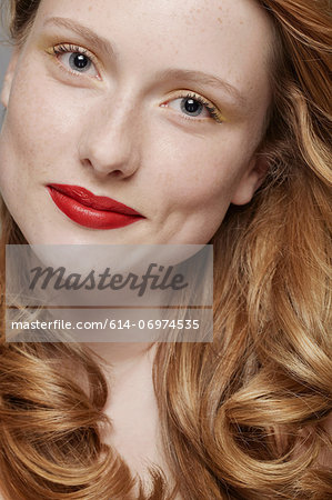 Studio shot of young woman with curly red hair wearing make up Studio shot of young woman with curly red hair wearing make up