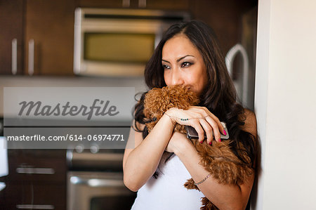 Portrait of mid adult female with dog and smartphone