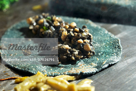 A quesadilla made with a blue corn tortilla with huitlacoche (corn fungus, Mexico) A quesadilla made with a blue corn tortilla with huitlacoche (corn fungus, Mexico)