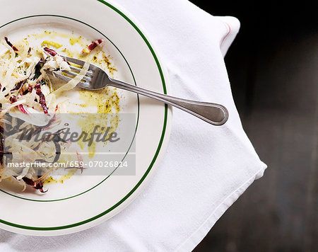 Partially Eaten Salad on a Plate with a Fork; From Above Partially Eaten Salad on a Plate with a Fork; From Above
