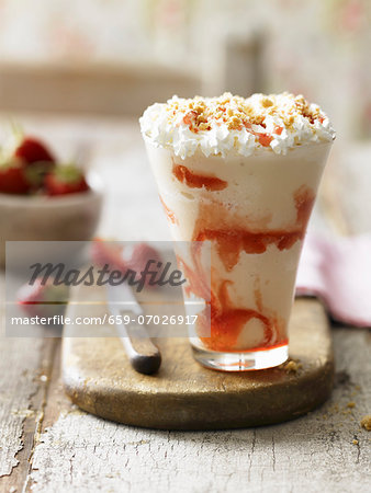 An ice cream sundae with strawberries, cream and shortbread