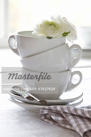 Stacked coffee cups decorated with white flowers Stacked coffee cups decorated with white flowers