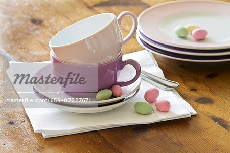 Stacked plates and coffee cups with pastel-coloured sugar eggs