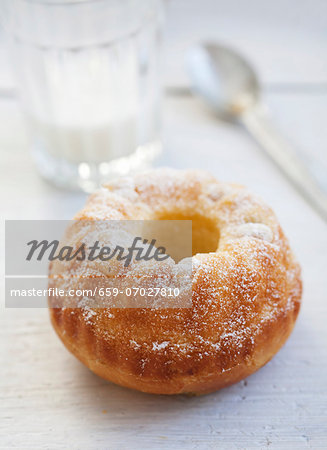 A mini Bundt cake with pieces of pear and icing sugar