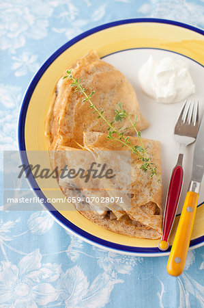 Banana Stuffed Crepes on a Plate with Fork and Knife
