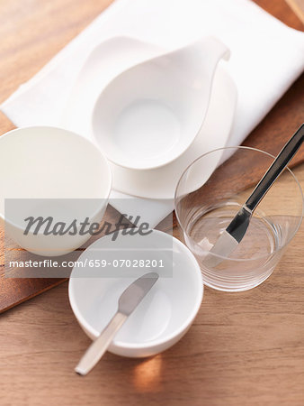 Empty porcelain bowls with a glass and a knife