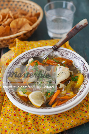 A Bowl of Fish Stew with Carrots and Yellow Bell Pepper