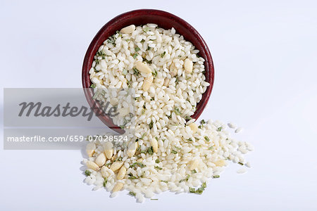 Vialone Nano risotto rice with pine nuts and chives in a ceramic bowl