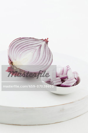 Half a red onion, and pieces of onion in a bowl